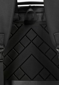 Zaino nero con un motivo geometrico testurizzato, materiale resistente, spallacci regolabili e un compartimento con zip in cima.