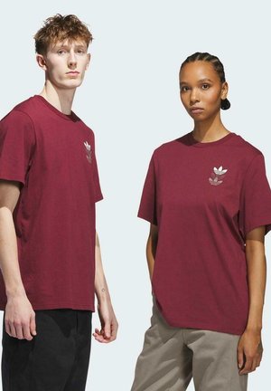Camisetas de algodón burdeos de manga corta, con un logotipo sutil en el pecho. Ambas tienen un corte relajado y diseño de cuello redondo.