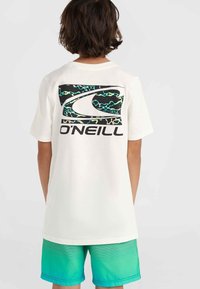Balta marškinėliai su dideliu juodu ir spalvotu O'Neill logotipu ant nugaros. Dėvimi su teal gradient spalvos šortais, turinčiais horizontalias juosteles.