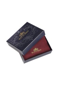 Donkerblauwe cadeauverpakking met een reliëf gouden logo en een ingewikkeld ontwerp. Bevat een bordeauxkleurig stoffen item met een gestructureerd patroon.