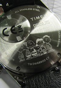 Montre-bracelet Timex avec dos en acier inoxydable, gravée de personnages de dessins animés de Peanuts ; bracelet en cuir noir, design résistant à l'eau.