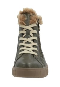 Baskets montantes en faux cuir vert avec un bord en fourrure beige, des lacets crème, une fermeture éclair sur le côté et une semelle en caoutchouc texturée.