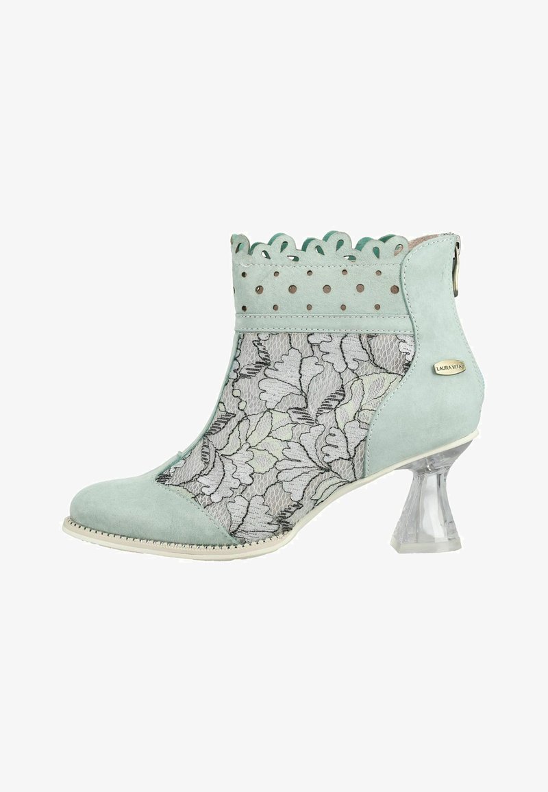 Bottine vert menthe avec panneaux latéraux en dentelle florale transparente, bord supérieur festonné avec perforations, et talon carré évasé transparent.