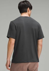 Herren T-Shirt mit kurzen Ärmeln aus dunkelgrauer Baumwolle. Glatte Textur, Rundhalsausschnitt, lockere Passform, schlichtes Design ohne Muster oder Akzente.