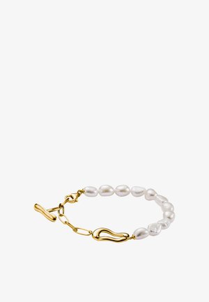 Bracciale in oro e perle bianche con perle di forma irregolare e due maglie d'oro testurizzate, posato su uno sfondo bianco.