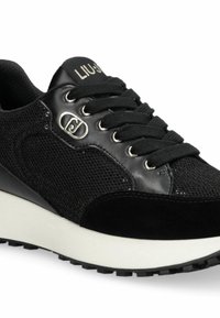 Baskets noires en mesh et cuir, bout rond, design à lacets, accents métalliques argentés et semelle intermédiaire blanche contrastante.