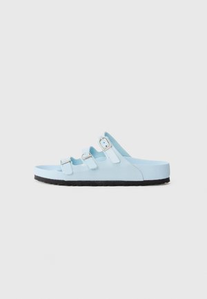 Light blue sandals with three adjustable straps, silver buckles, and a thick black rubber sole. Smooth texture, open back design.