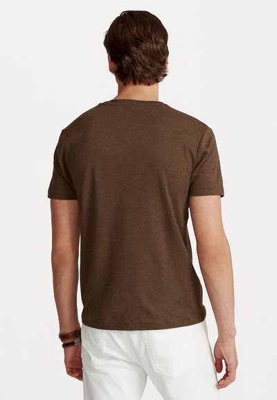Ruskea lyhythihainen t-paita pyöreällä kaula-aukolla, valmistettu pehmeästä materiaalista. Takakuvassa näkyy sileä rakenne ja rento istuvuus.