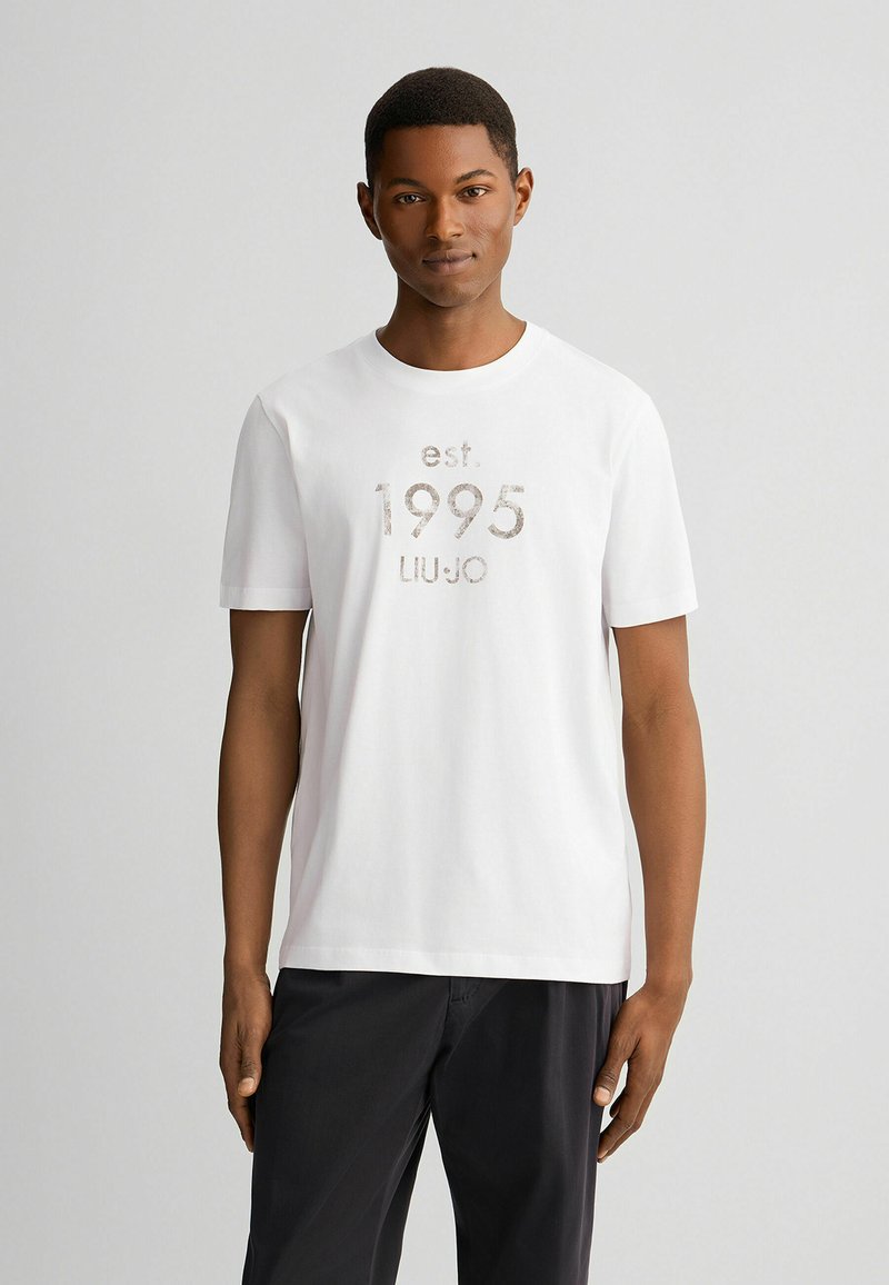 Witte katoenen T-shirt met korte mouwen. De voorkant heeft een textuurprint met "est. 1995 LIU JO" in een contrasterende kleur. Eenvoudig, klassiek ontwerp.