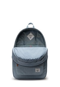 Modrý látkový batoh zaobleného tvaru, s přední kapsou na klopě, pruhovanou vnitřní podšívkou a diamantovou nášivkou s logem.