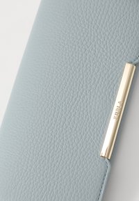 Light blue textured leather wallet featuring a gold-colored metal accent with the brand name embossed. Smooth edges and minimalist design.