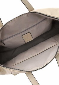 Beige Lederhandtasche innen mit glatter Textur, mit einem Reißverschlussfach und einem Einschubfach. Reißverschlussverschluss oben.