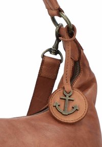 Sac en cuir marron avec une texture lisse, doté d'une fermeture éclair et d'un pendentif en bronze en forme d'ancre comme détail remarquable sur la sangle.