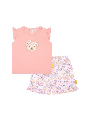 Top rosa senza maniche con maniche arricciate e applicazione di orsetto, abbinato a pantaloni corti a fiori nei toni rosa, blu e giallo.