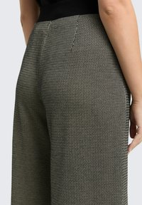 Broek in een zwart-wit zigzagpatroon met textuur, hoge taille, een gladde tailleband en zijkanten zakken.