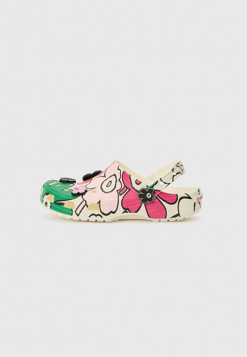 Sabot enfant à enfiler avec bride au talon, orné de grands motifs floraux roses et verts et de breloques noires en forme de fleurs.