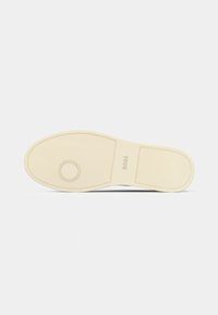 Suela de zapato de goma blanca con una superficie texturizada y detalle circular, con la marca "BOSS". Bordes suaves y sin patrones.