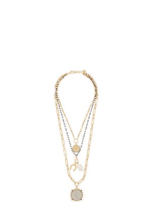 Naszyjnik warstwowy składający się z trzech łańcuszków: złotych metalowych ogniw z czarnymi koralikami, okrągłej ozdobnej zawieszki oraz akcentu z kryształu.