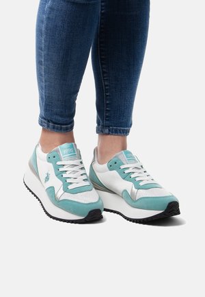 Lichtblauwe en witte sneakers met zilveren accenten, met een gestructureerde bovenkant, vetersluiting en een zwarte rubberen zool.