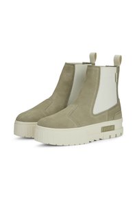 Stivaletti alla caviglia in suede verde con pannelli laterali elastici bianchi, finitura texturizzata, suola spessa bianca e accento del logo dorato sul lato.