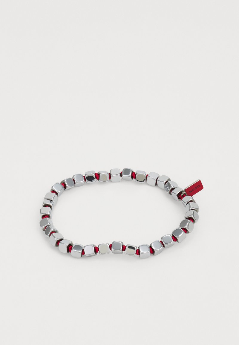 Silver-colored bracelet made of rounded metal cubes interspersed with red accents, featuring a small red tag labeled "HUGO."