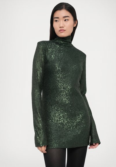 Zöld flitteres garbó pulóver bordás textúrával, hosszú ujjakkal és testhez simuló szabással. Csillogó részletei kiemelik a fényt.