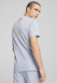 Tricou din bumbac de culoare albastră deschisă, cu mâneci scurte, guler rotund și un croi lejer. Textură fină, design minim, potrivit pentru ținute casual.