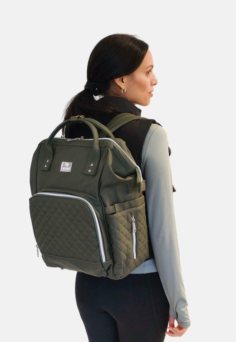 Mochila verde oliva hecha de tela acolchada con múltiples compartimentos, asas redondeadas y acentos de metal plateado.