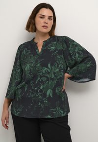Blusa blu scuro con motivo floreale verde, scollatura a V e maniche puff a tre quarti, realizzata in un tessuto leggero.