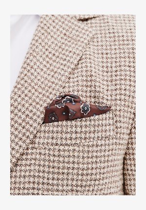 Brązowa marynarka w kratę z teksturowanym wzorem, z brązową chusteczką w kieszeni ozdobioną niebieskimi i białymi motywami kwiatowymi.