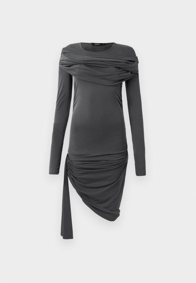 Mørk grå langermet tettsittende kjole med drapert stoff over brystet og asymmetrisk rynkeskjørt med hengende bånd på den ene siden.