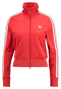 Röd zip-jacka i slätt tyg, med hög krage, vita randaccentuerade ärmar och adidas-logga på bröstet.