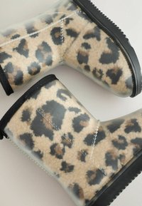 Skaidrios kulkšnai batai su smėlio ir juodo leopardų raštu, su tekstūruota audinio pamušalu, juodu apdaila ir tvirtu juodu padu.