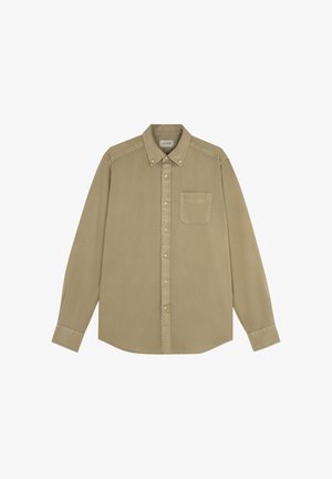 Camisa beige de manga larga con botones, cuello abotonado y un solo bolsillo en el pecho, mostrada extendida sobre un fondo blanco.