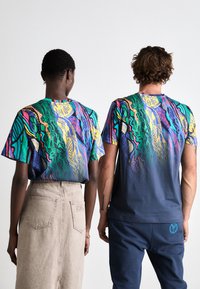 T-Shirts mit kurzen Ärmeln weisen ein mehrfarbiges, abstraktes Design mit lebhaften Grüntönen, Blautönen, Gelbtönen und Rosatönen auf, das zu einem einheitlichen Marineblau am unteren Ende verblasst.