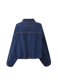 Donkerblauwe spijkerjas met lange mouwen, elastische manchetten en een genaaide rechthoekige patch op de achterkant met tekst.
