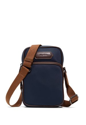 Bolso bandolera compacto de color azul marino con correa ajustable marrón y bolsillo frontal con cremallera, con parche del logo "ALDO" en relieve.