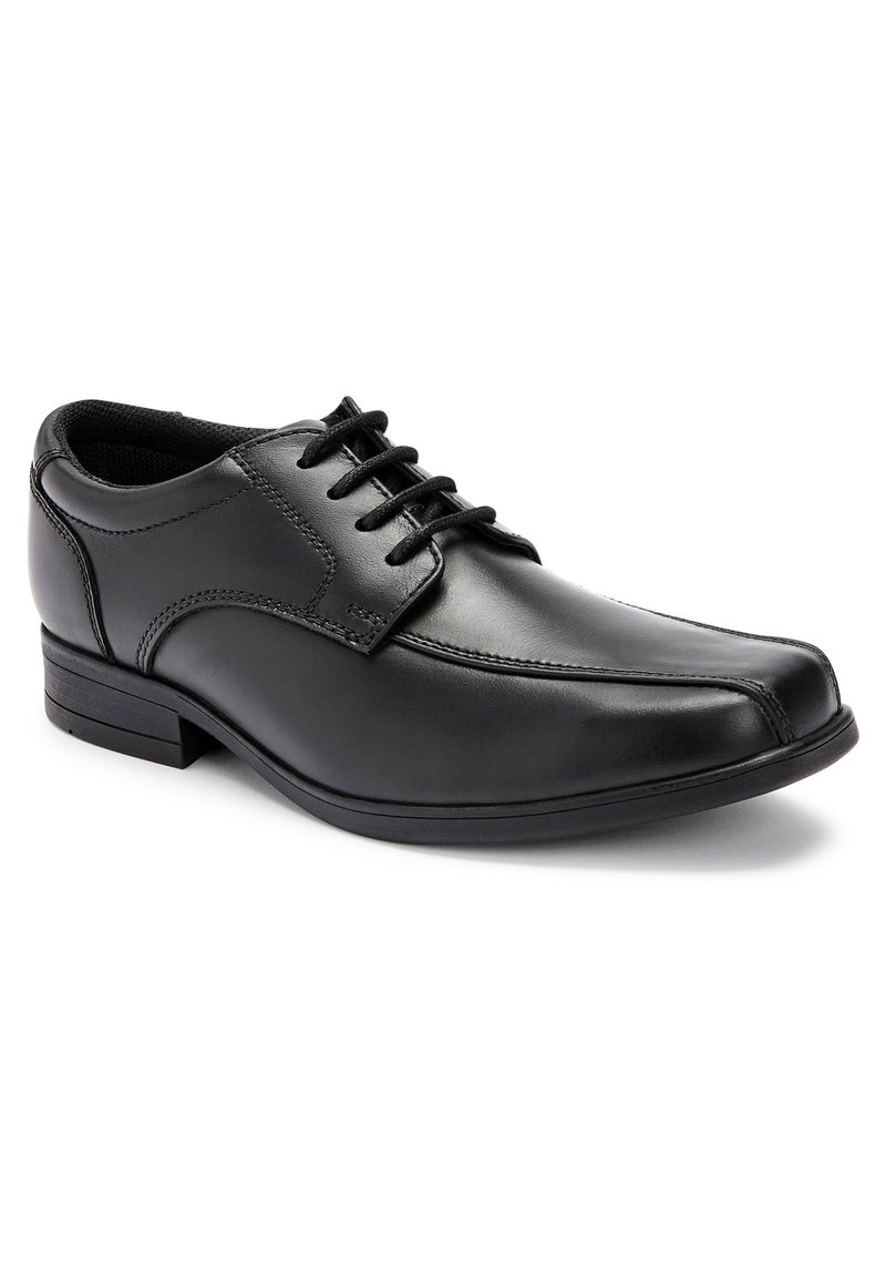 Chaussure habillée en cuir noir avec un bout pointu et élégant, fermeture à lacets, surface texturée et un petit talon. Des coutures discrètes sont visibles.
