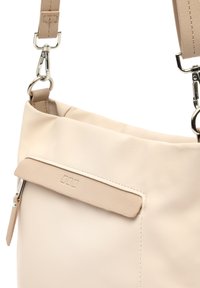 Borsa a tracolla beige realizzata in materiale sintetico liscio, con una tasca a pattina con un accento in pelle e accessori in metallo argentato.
