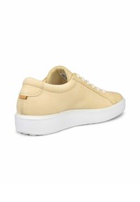 Baskets en cuir jaune avec semelle en caoutchouc blanche, bout rond et lacets blancs. Comprend un dos texturé et un petit onglet d'accent beige.