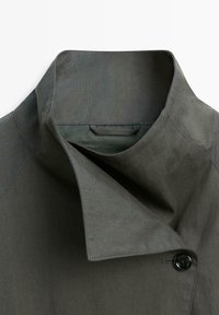 Donkergrijze jas met opstaande revers en een enkele zwarte knoopsluiting op een effen achtergrond.