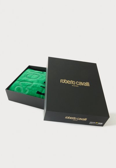 Μαύρο κουτί Roberto Cavalli Home μερικώς ανοιχτό, με ένα διπλωμένο πράσινο υφασμάτινο μέσα σε λευκό φόντο.