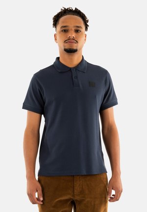 Mørkeblå polo T-shirt med et tekstureret mønster, tre-knaps knaplukning og en sort logo-patch på brystet. Korte ærmer.