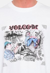Camiseta de algodón blanca con una impresión gráfica de un skater y un fotógrafo, con colores vibrantes y contornos de estilo de dibujos animados.