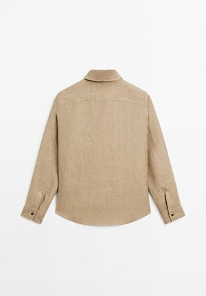 Chemise beige à manches longues avec des poignets boutonnés vue de dos, dotée d'un col droit et de détails de couture simples.