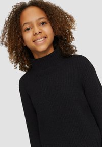 Pull en maille noire à col roulé avec un motif texturé. Coupe décontractée et détails de col côtelé, avec des manches longues et une couleur unie.