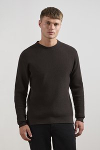 Dark brown ribbed knit sweater with a round neckline, long sleeves, and a ribbed hem. Smooth texture with a fitted silhouette.