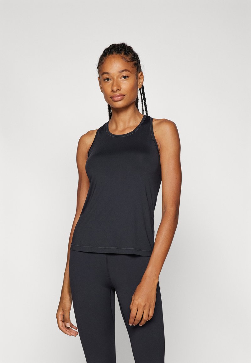 Svart trenings-tanktop med rund utringning og kontrasterende sømdetaljer, kombinert med matchende svarte leggings. Glatt stoff, ermeløs design.