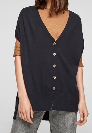 Donkerblauwe cardigan met een diepe V-hals en korte mouwen, voorzien van zes metalen knopen aan de voorkant. Draag het over een bruine top.