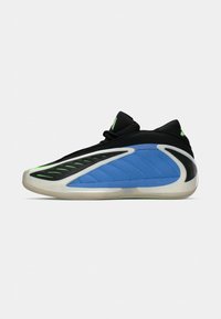 Zapatilla deportiva negra y azul con acentos verdes, parte superior texturizada, diseño aerodinámico y suela de goma con surcos diseñados.